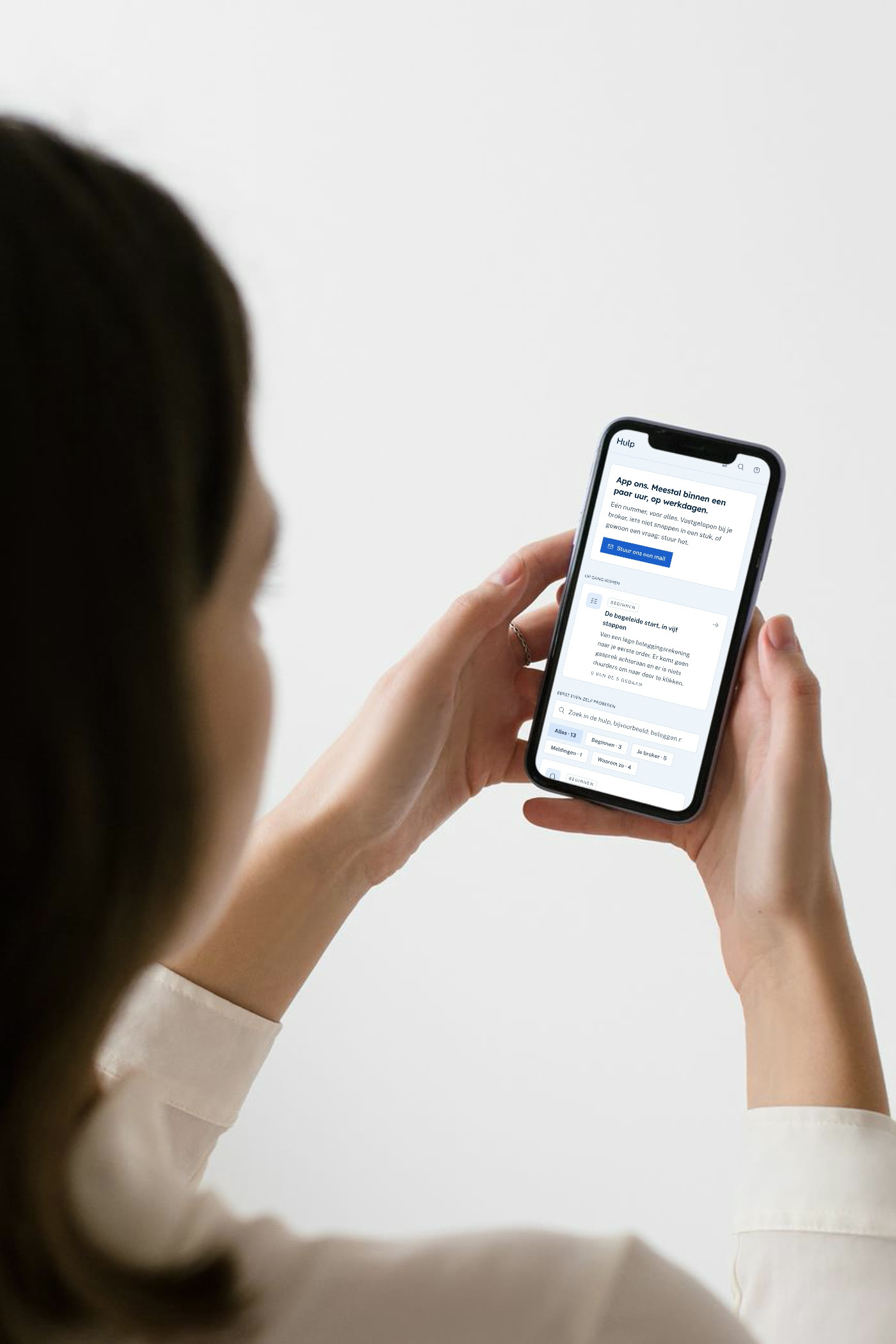 Over de schouder van een vrouw met de app van Seinr op haar telefoon